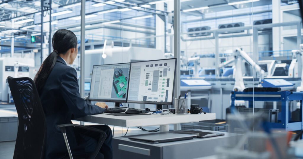 Asian Female Industrial Engineer working on a Computer in an office setting.